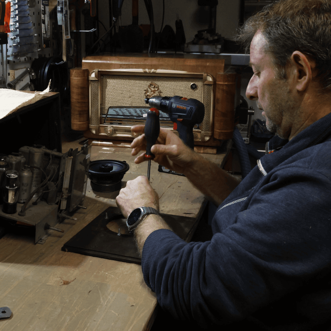 Sylvain, technicien d'A.bsolument, en train de moderniser une radio vintage dans son atelier