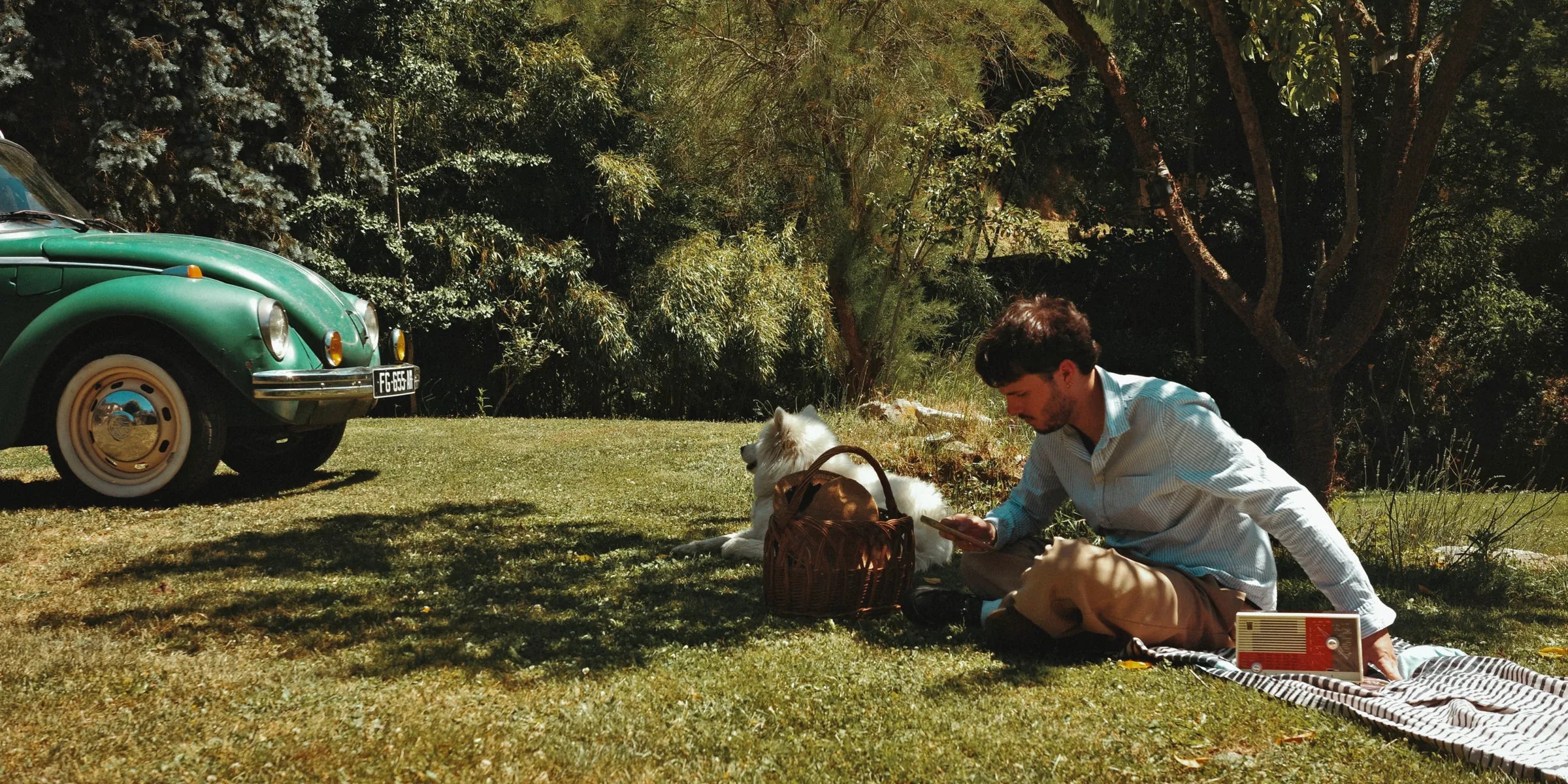 Radio vintage modernisée Bluetooth A.bsolument lors d'un pique-nique au jardin, avec un chien Samoyède et une Coccinelle verte